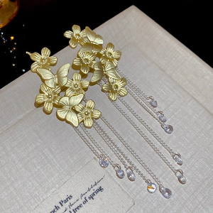 Detail shot of vintage butterfly floral earrings with long flowing tassels and zircons