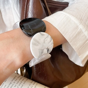 Close-up of marble-textured acrylic bracelet worn on wrist with elegant urban style