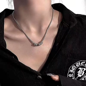Detail of silver chain necklace with multiple circular rings on black shirt