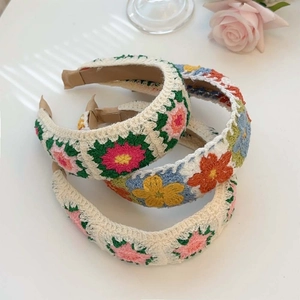 Three handmade crochet floral headbands in cream with colorful 3D flower patterns