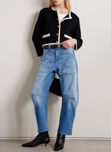 Detail of high-waisted wide-leg jeans with vintage washed texture and cargo pockets