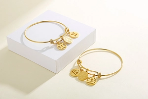 Macro view of adjustable gold constellation bracelets with Gemini and Libra charms