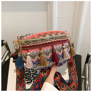 Close-up of bohemian woven crossbody bag with vibrant colorful tassels and patterned strap