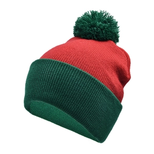 Detail of red and green knitted Christmas beanie featuring thick ribbed texture and pompom