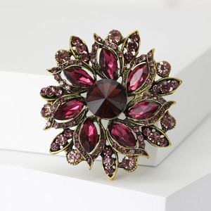 Macro detail of vintage floral brooch with purple crystals and antique gold finish