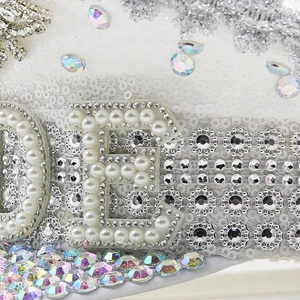 Close-up of white sequin captain hat with pearl and rhinestone letter decoration