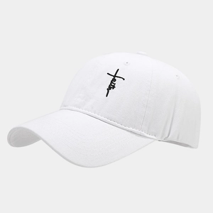Close-up of black 'faith' embroidery with a cross on a white canvas baseball cap