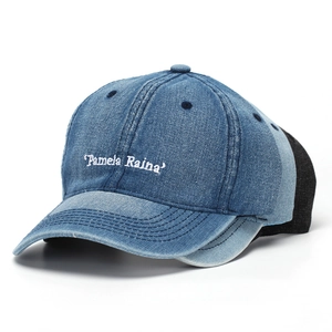 Close-up of letter embroidery on blue washed denim baseball cap with six-panel design