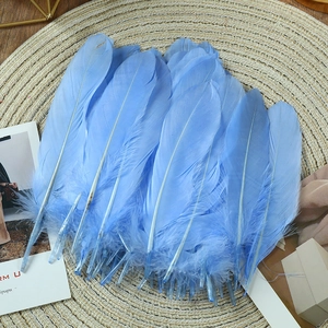 Macro shot of light blue natural goose feathers on a woven mat for DIY craft projects