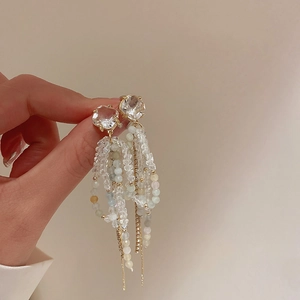 Detail of elegant bow tassel earrings with blue beads and faceted crystal stones