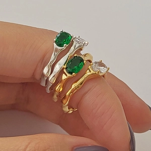 Detail of irregular hammer-textured rings with green and clear zircon stones