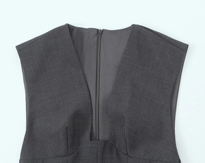 Detail view of deep V-neckline and invisible back zipper on a dark gray dress