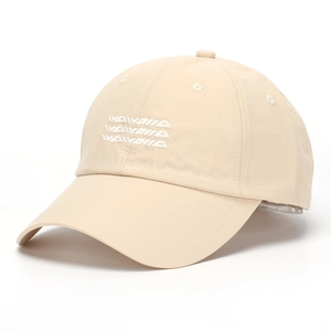 Close-up of white letter embroidery and breathable fabric on beige baseball cap