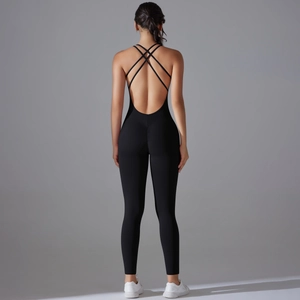 Close-up of ruched butt detail and cross back straps on black compression jumpsuit