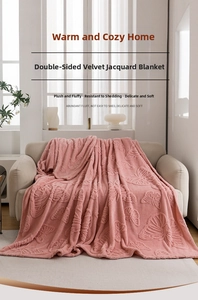 Detail of pink flannel blanket with 3D butterfly jacquard pattern on a cozy beige sofa