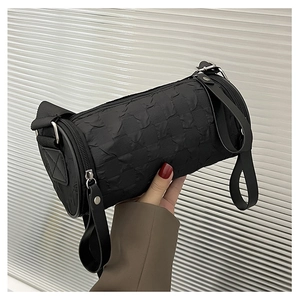Detail view of black cylindrical crossbody bag with 3D checkered pleated texture
