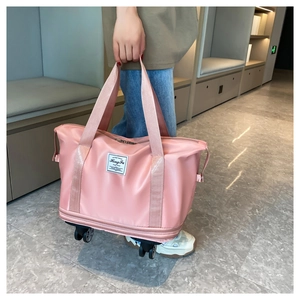 Detail of pink expandable travel bag with smooth universal wheels and sturdy handles
