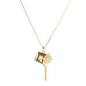Détail macro du pendentif frites avec zircons noirs et blancs sur chaîne dorée