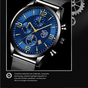 Detailed macro view of the blue luminous dial with calendar display and silver mesh strap