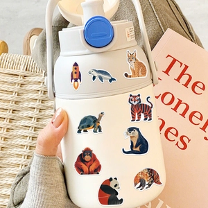 Cute animal and space themed stickers on a white water bottle with warm lighting