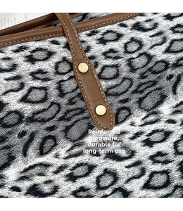 Détail du sac léopard avec bandoulière en cuir marron et rivets dorés de renforcement