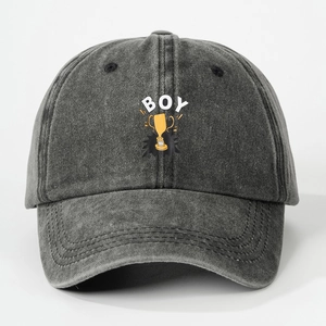 Detail of grey washed denim baseball cap featuring yellow trophy print and BOY lettering
