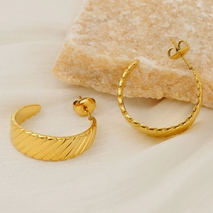 Detail of 18K gold-plated stainless steel C-shaped earrings with diagonal textured surface