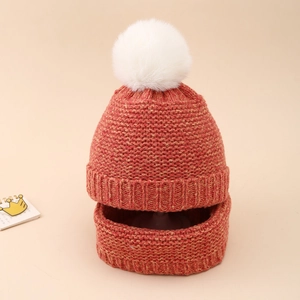 Detail of coral orange knit baby hat and scarf set with soft white faux fur pompom