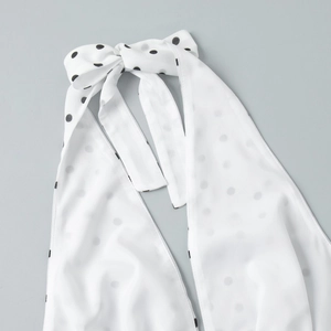 Detail of white polka dot halter top showing the tie-up bow neckline and chiffon fabric