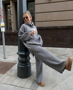 Outdoor shot of a woman in a grey knitted two-piece lounge set with wide-leg pants