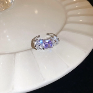 Macro view of palace style silver ring featuring square purple zircon and crystal accents
