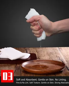 Detailed shot of soft white disposable towel being wrung out showing high water absorption