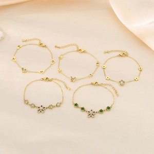 Detail of gold-plated bracelets featuring zircon heart, butterfly, and flower charms