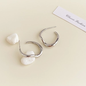Detailed macro view of silver irregular geometric earrings with a polished finish texture