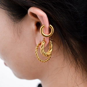 Golden stainless steel hoop earring set featuring polished cuff and twisted hoop designs