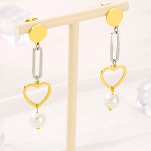 Elegant gold heart and white pearl drop earrings on a display stand with ice blocks