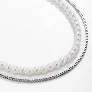 Double-layered hip hop necklace featuring faux pearl strand and silver box chain on white background