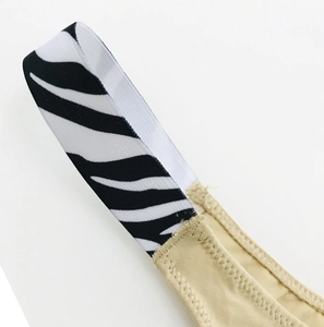 Close-up of zebra print elastic waistband stitched to beige cotton fabric detail