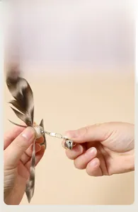 Detail view of cat teaser wand replacement feather head with bell and metal connector