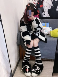Detail of black and white striped leg warmers paired with plush sneakers and accessories