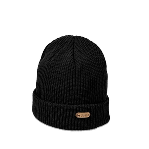 Detail of black knit beanie featuring a brown leather deer patch and thick rib texture
