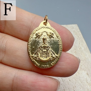 Macro shot of gold Virgin Mary oval pendant with religious relief and 1830 engraving