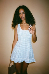 Detail of blue and white plaid dress showing front buttons and tiered ruffle hem