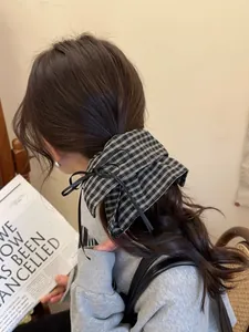Classic black and white checkered hair scrunchie with bow tie shown on low ponytail
