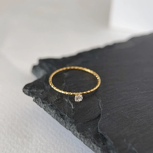 Macro shot of 18k gold plated thin twist ring with a sparkling crystal zircon stone