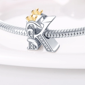 Close-up of letter K charm with gold crown and crystals on silver snake chain