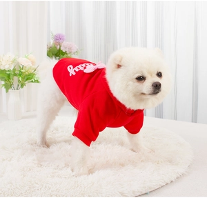 Detail of red dog hoodie with plush lining, pink bow, and leashing hole on Pomeranian
