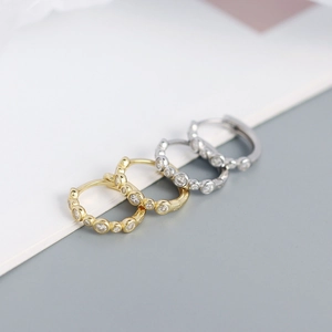 Macro shot of gold and silver S925 sterling silver hoop earrings with clear cubic zirconia