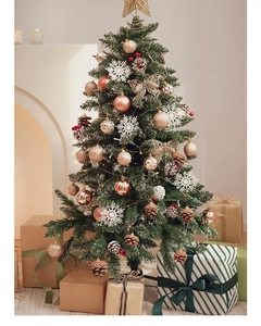Close-up of a Christmas tree with golden ornaments, berries, and a warm glowing tree topper