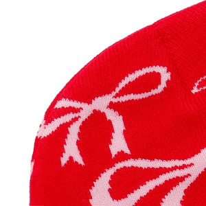 Detailed macro view of the red knit fabric featuring a soft pink bow jacquard pattern